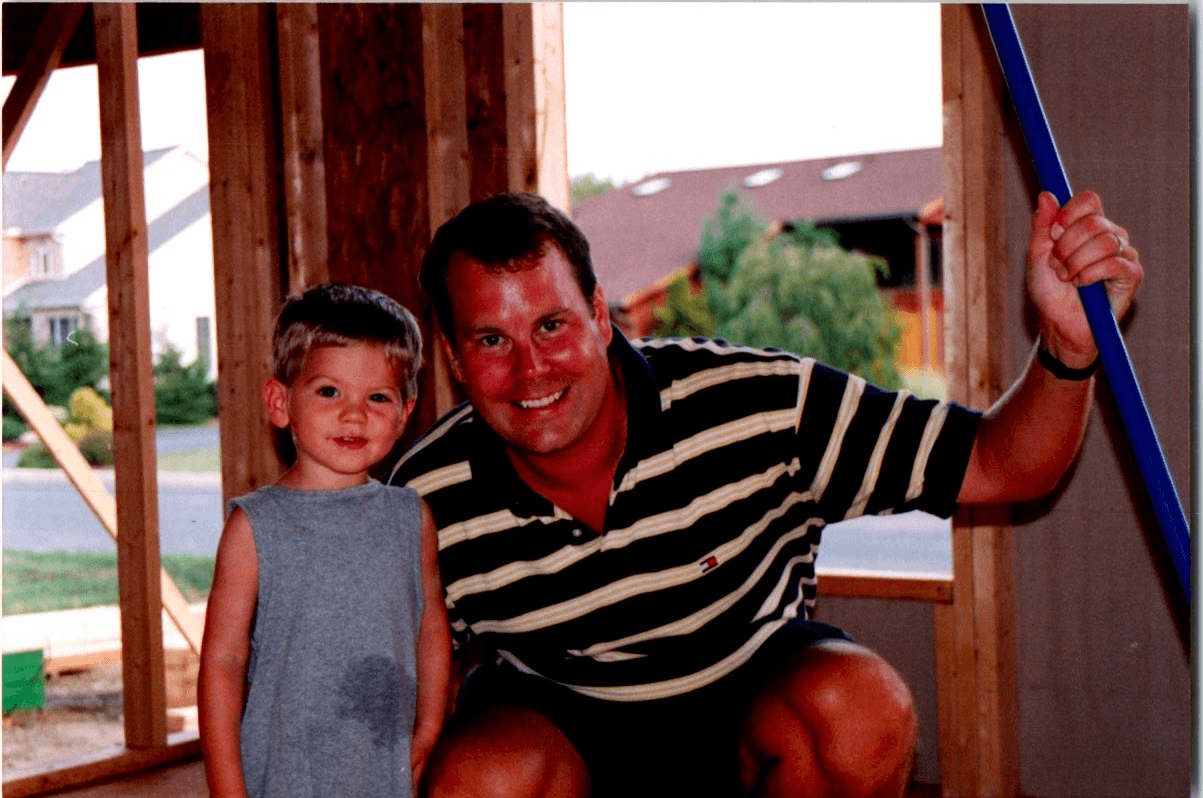 Dad and me inside the wood framing of a house under construction
